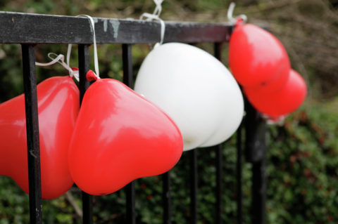 Heart-shaped balloons at a fence