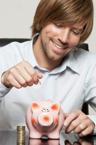 Man putting coin into piggy bank