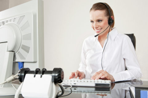 Smiling young woman wearing headset in office