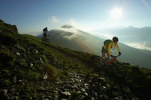 Two bicyclists in back light