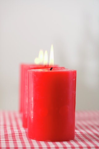 Four burning red candles in a row