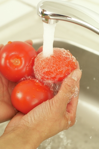 Woman washing tomatoes