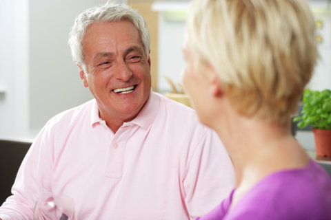 Gray-haired man smiling at a blonde woman, selective focus