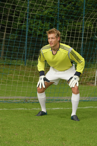 Young goalkeeper watching the game concentrated
