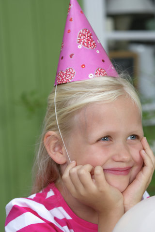 Little blond girl with a cornet on her head, close-up