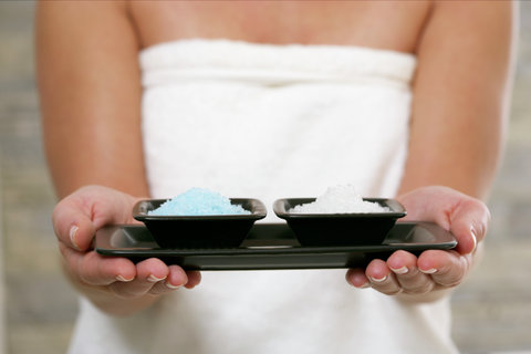 Young woman holding dishes with salt crystals