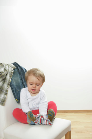 Baby boy playing with a shirt