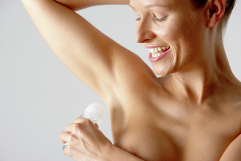 Young woman putting on an antiperspirant (part of), close-up