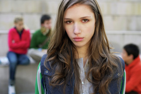 Young woman looking at camera, group in background