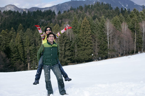 Young man giving woman a piggyback 