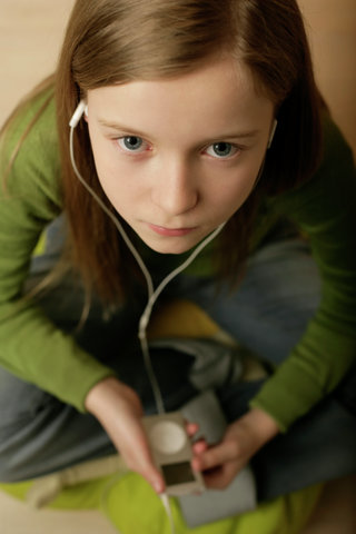 Girl listing to music of a MP3-player by earphones