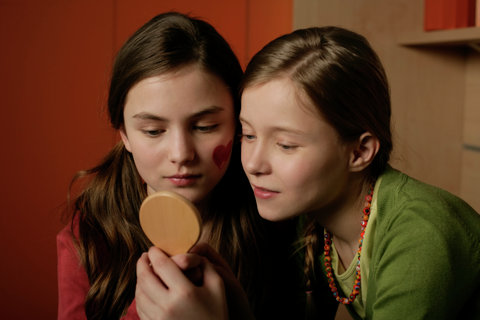 Two friends looking into a mirror