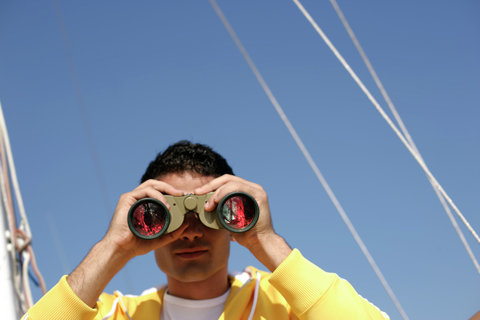 Man looking trough binoculars