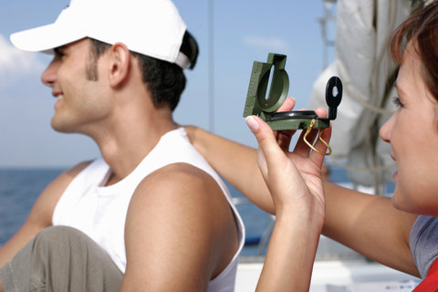 Woman putting her hand on man's shoulder, using a compass