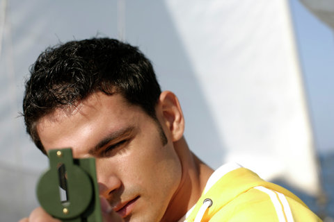 Man using hand bearing compass