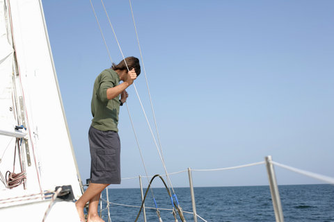 Man standing on a sailboat