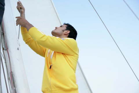 Man hoisting a sail