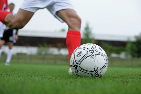 Soccer player kicking a football