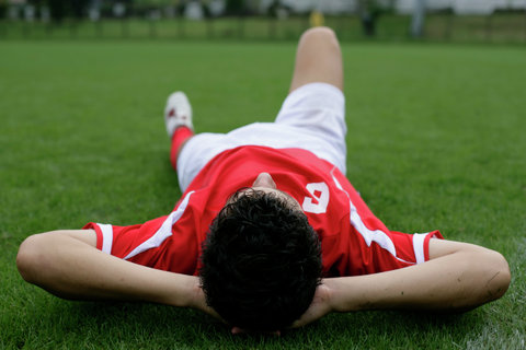 Soccer player lying on grass