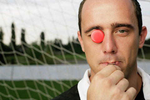 Referee with red chip in his eye whistling