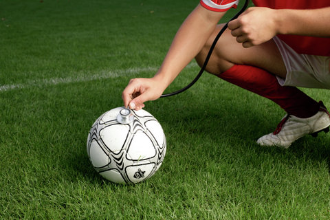 Soccer player checking football with a stethoscope