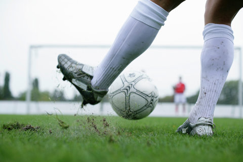 Soccer player kicking football