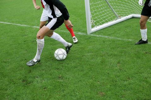 Soccer players in action in front of a goal