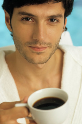 Darkhaired Man in a Bathrobe holding a Cup of Coffee in his Hand - Look - Hot Beverage - Leisure Time