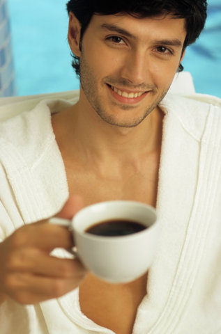 Darkhaired Man in a Bathrobe holding a Cup of Coffee in his Hand - Look - Hot Beverage - Leisure Time